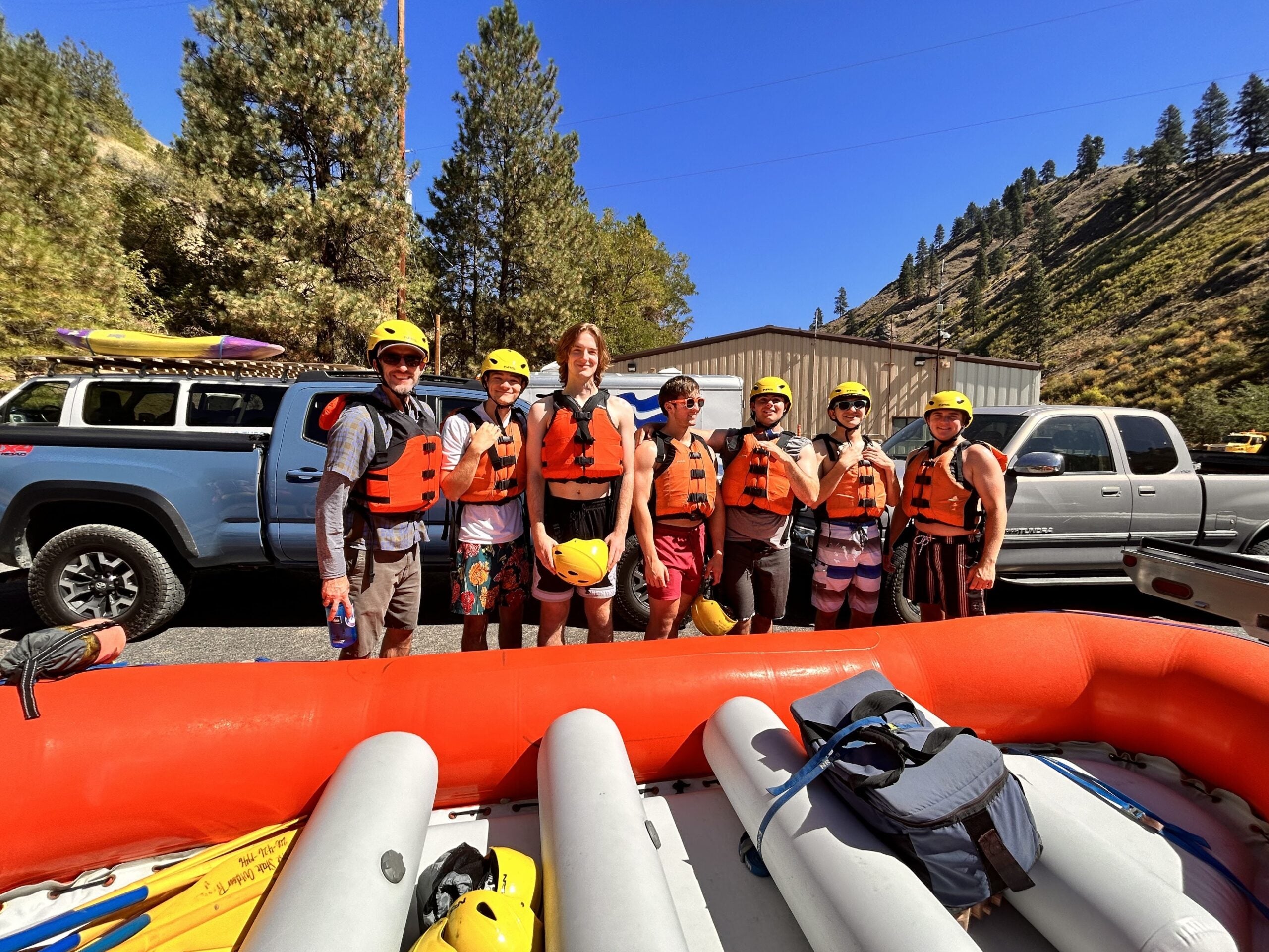 Health Professions Living Learning Community Faculty-out-of-residence Travis Armstrong poses with his Living Learning Community students in lifevests and helmets ready to river raft