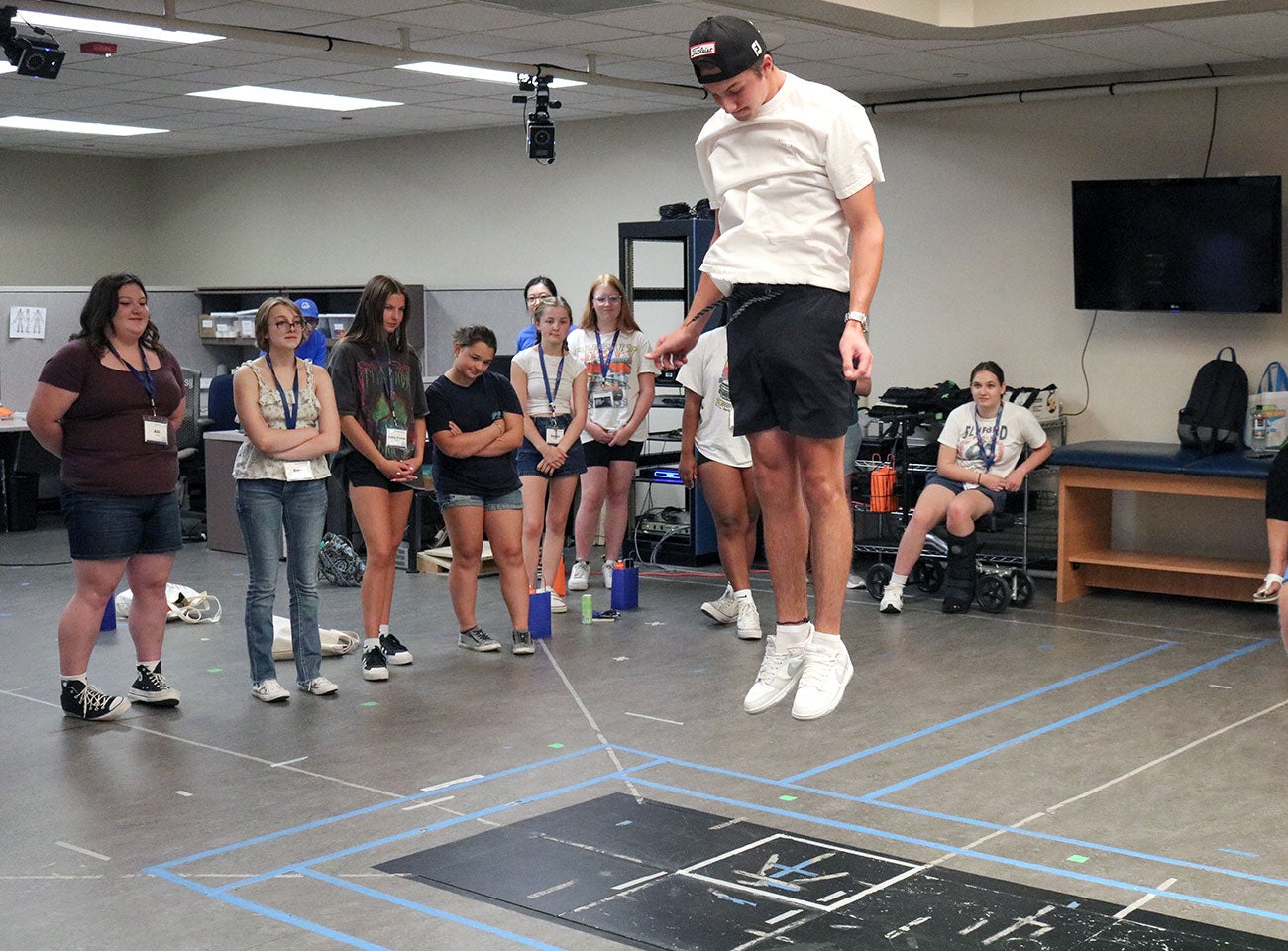 Carson jumps as high as he can on a force plate at the Center for Orthopaedic and Biomechanics Research lab while other campers watch