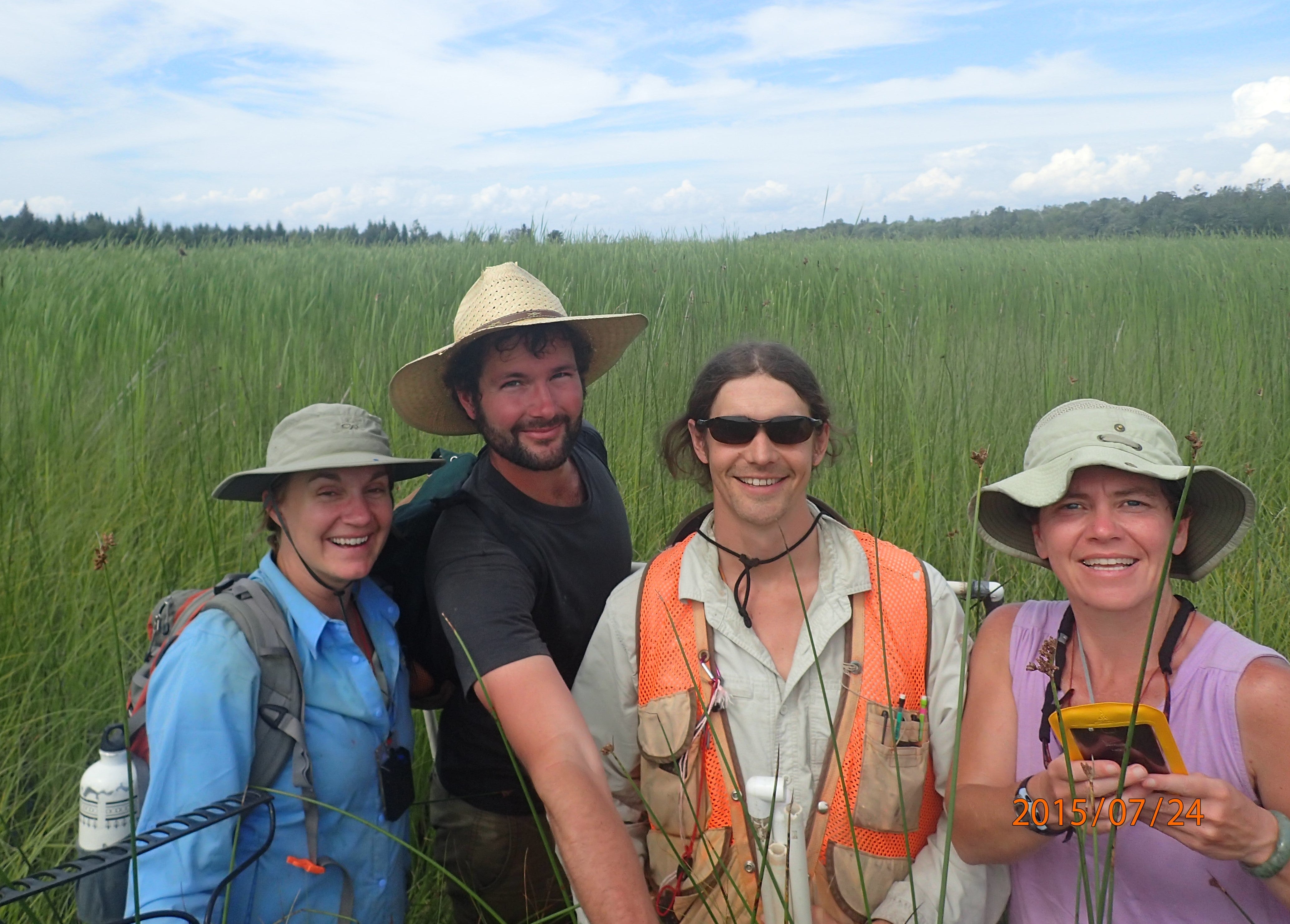 A group of individuals posing in a wet land