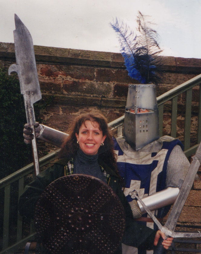 Lisa McClain poses with a shield next to a knight