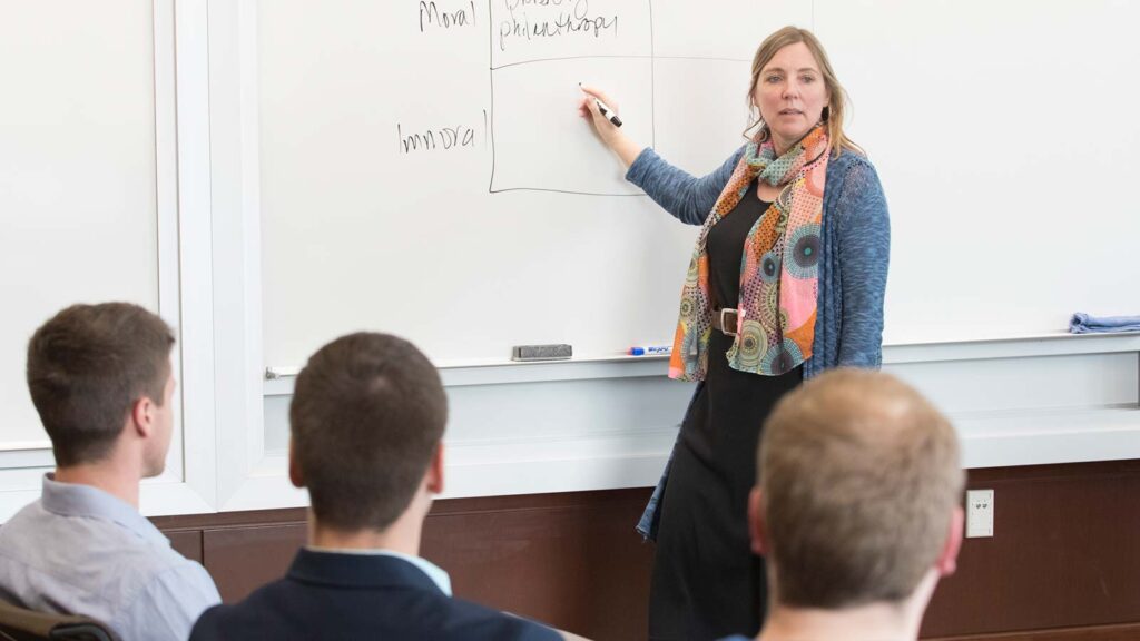 faculty lecturing and writing on a white board