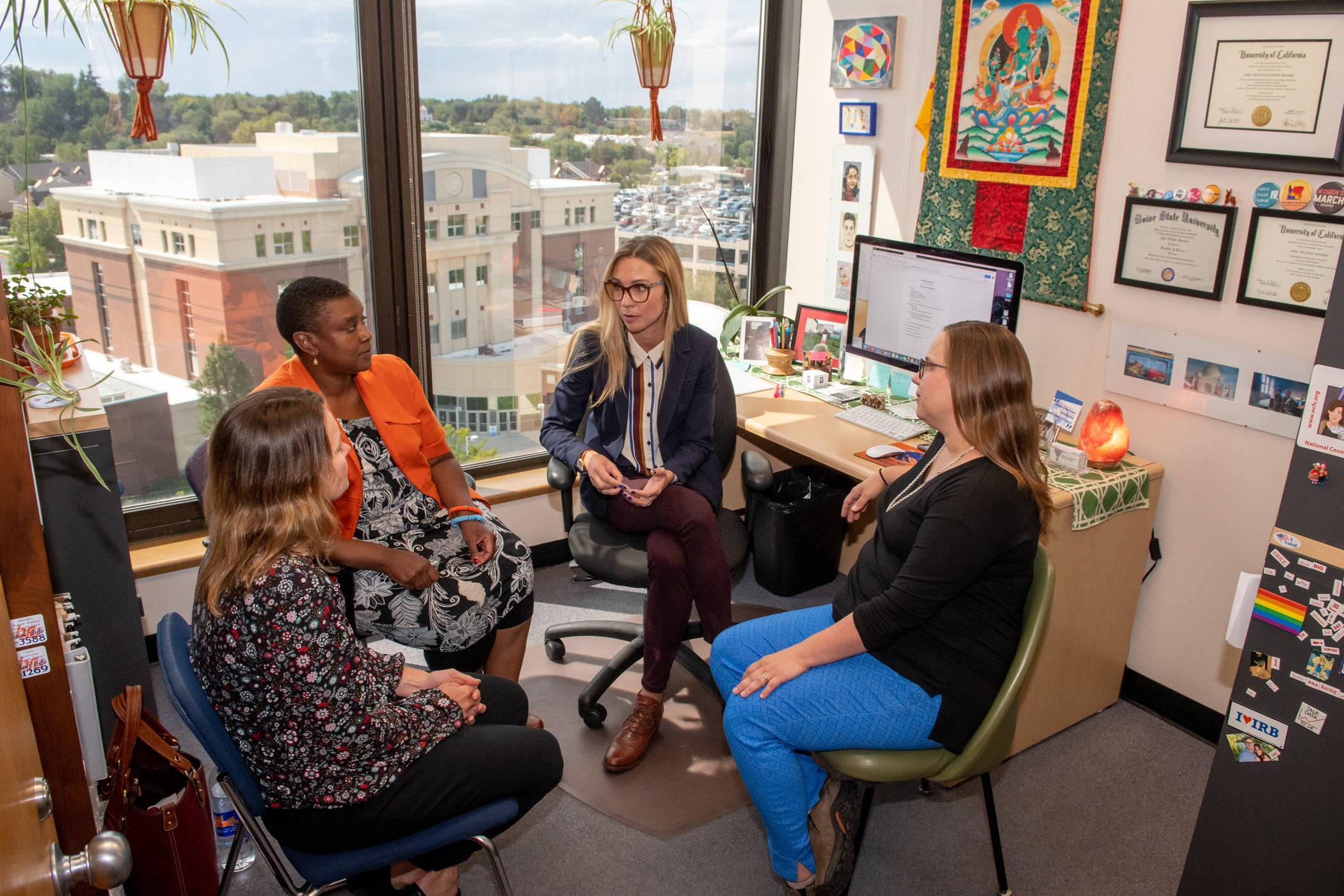 a group of employees meet together in an office