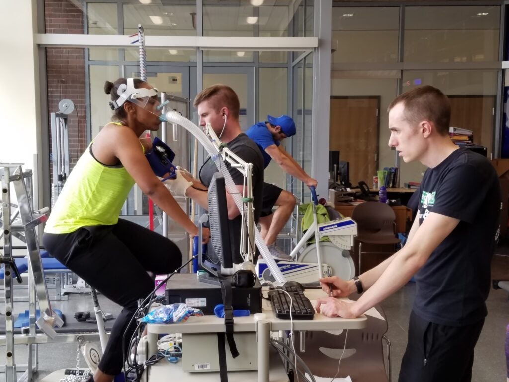 person using exercise equipment hooked up to testing equipment