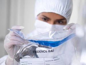 forensic scientist putting hammer in evidence bag