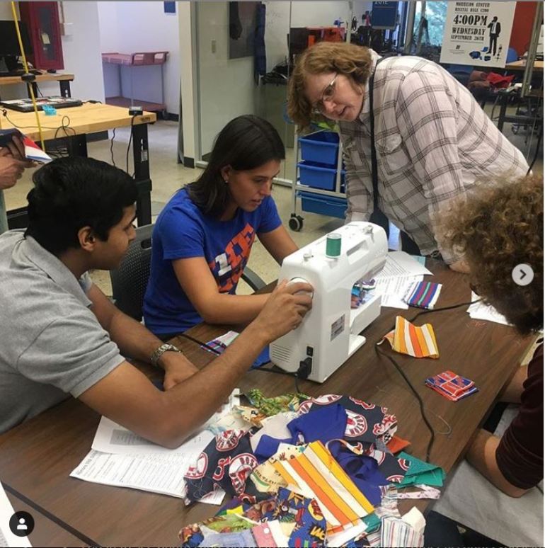 students work together at a sewing machine