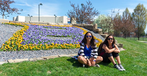 Students in front of B flowers on campus