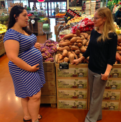 Two women chat in a grocery store