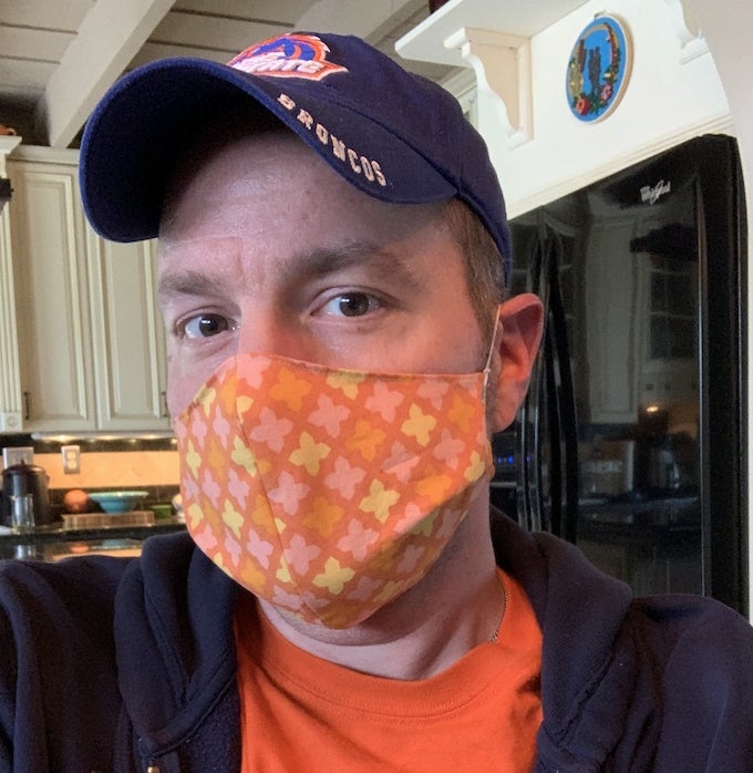 Man wering orange patterned protective face mask