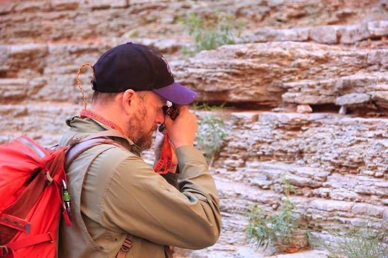 Professor Schmitz uses handheld device to inspect stone sample