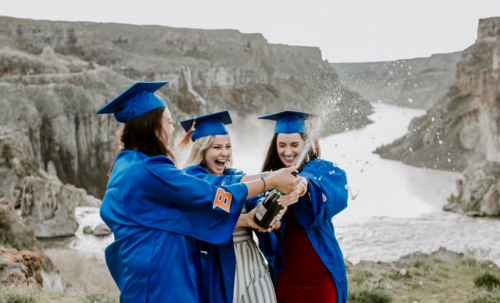 Three students celebrate graduation in gowns