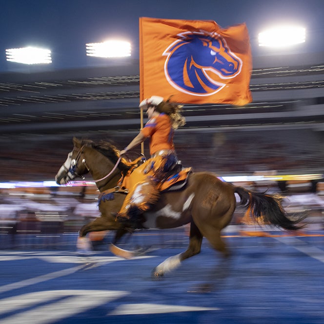 Bronco horse rider races across Bronco field