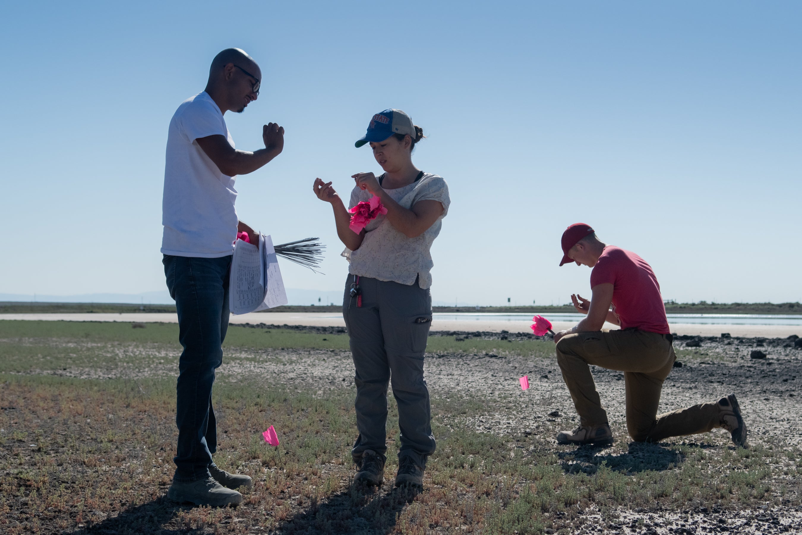 three students conduct survey work in desert