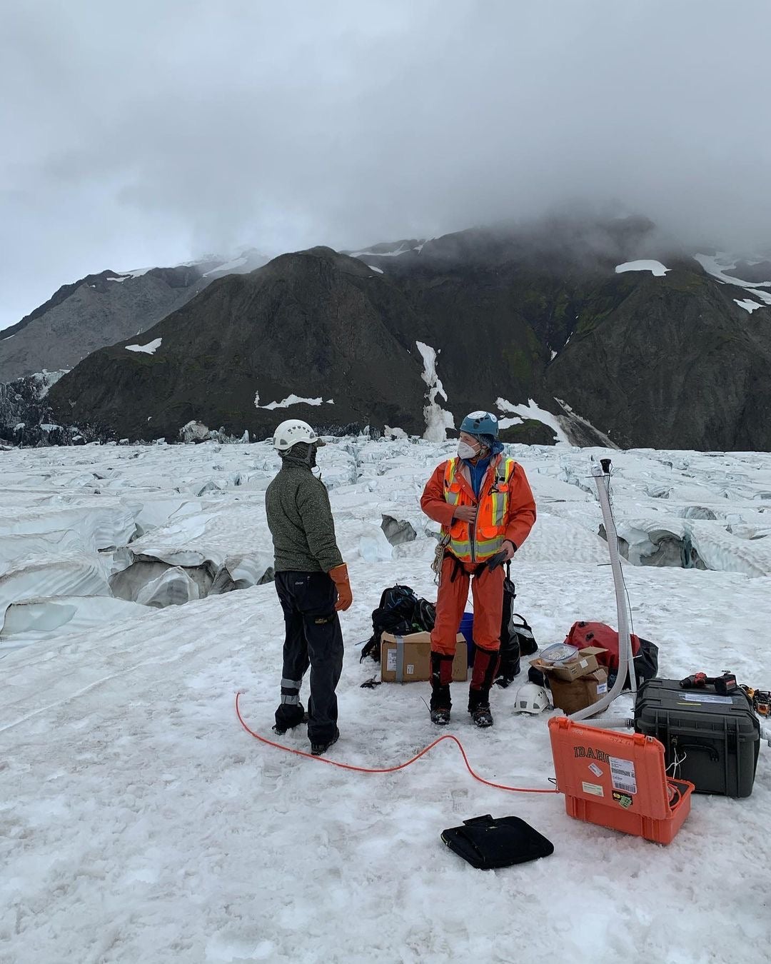 researchers surrounded by equipment, standing on glacier