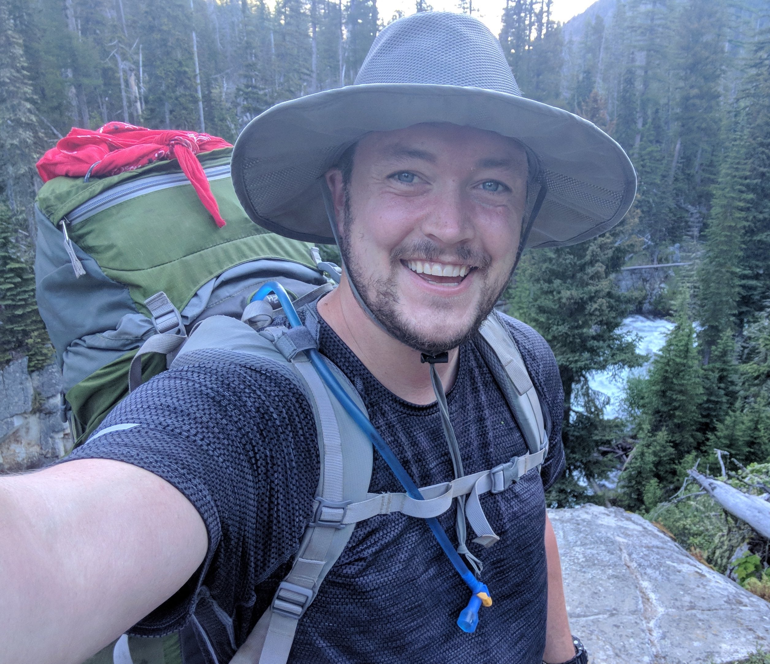man in woods wearing hiking gear and hat