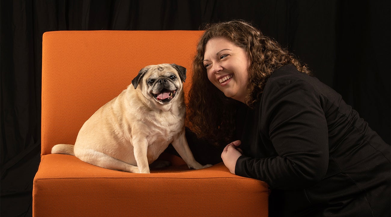 Shelly Volsche and her dog, Lucy on an orange chair