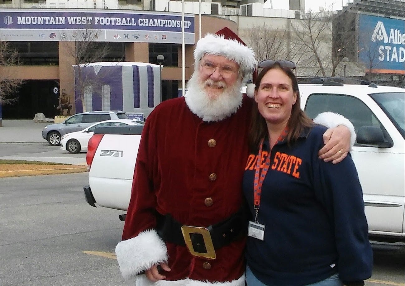 A woman poses for a photo with Santa Claus 