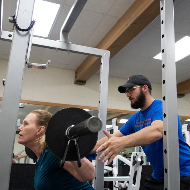 Trainer and client in weight room