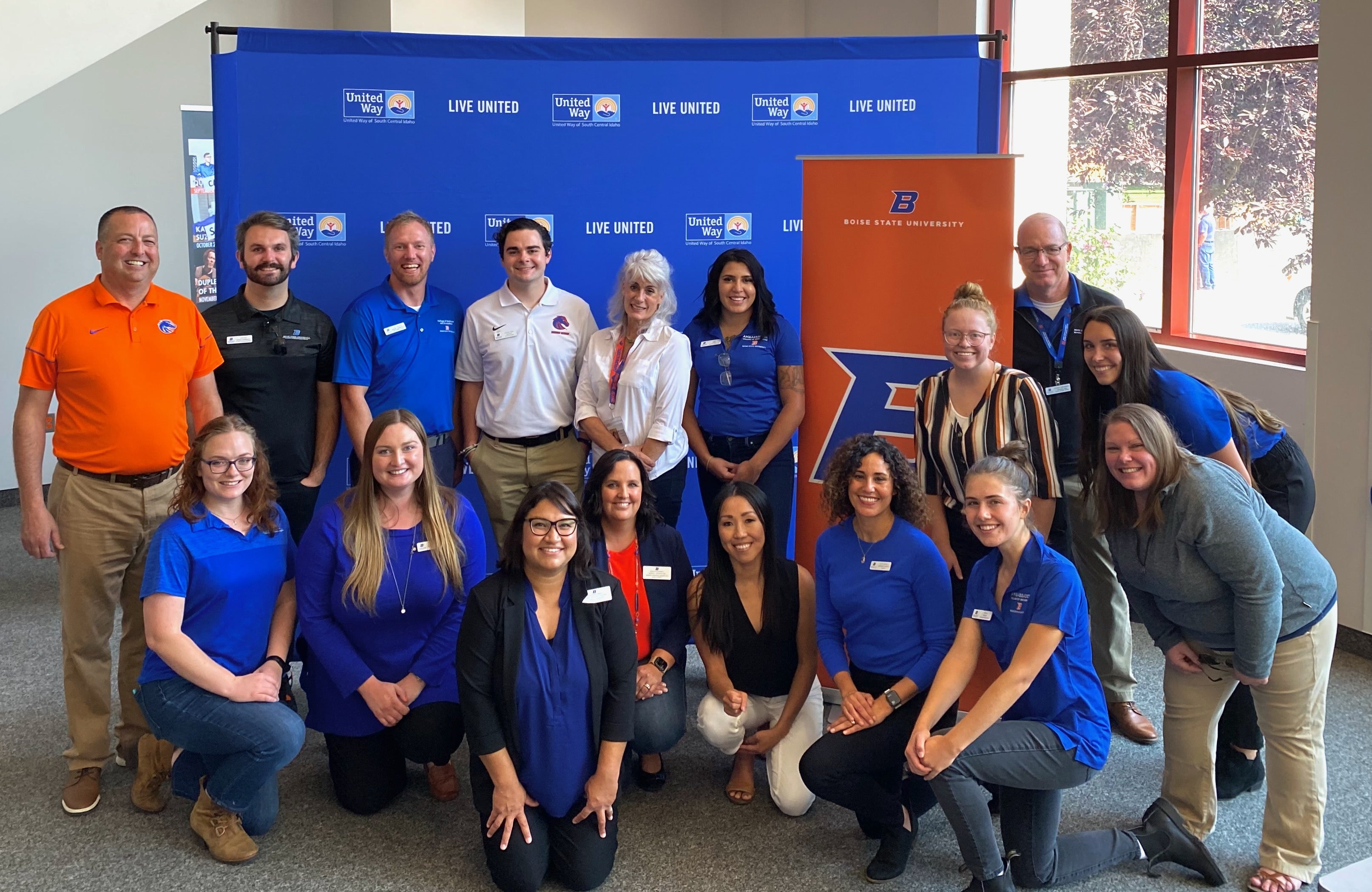 Boise State Day staff in a group in front of a blue photo backdrop. 