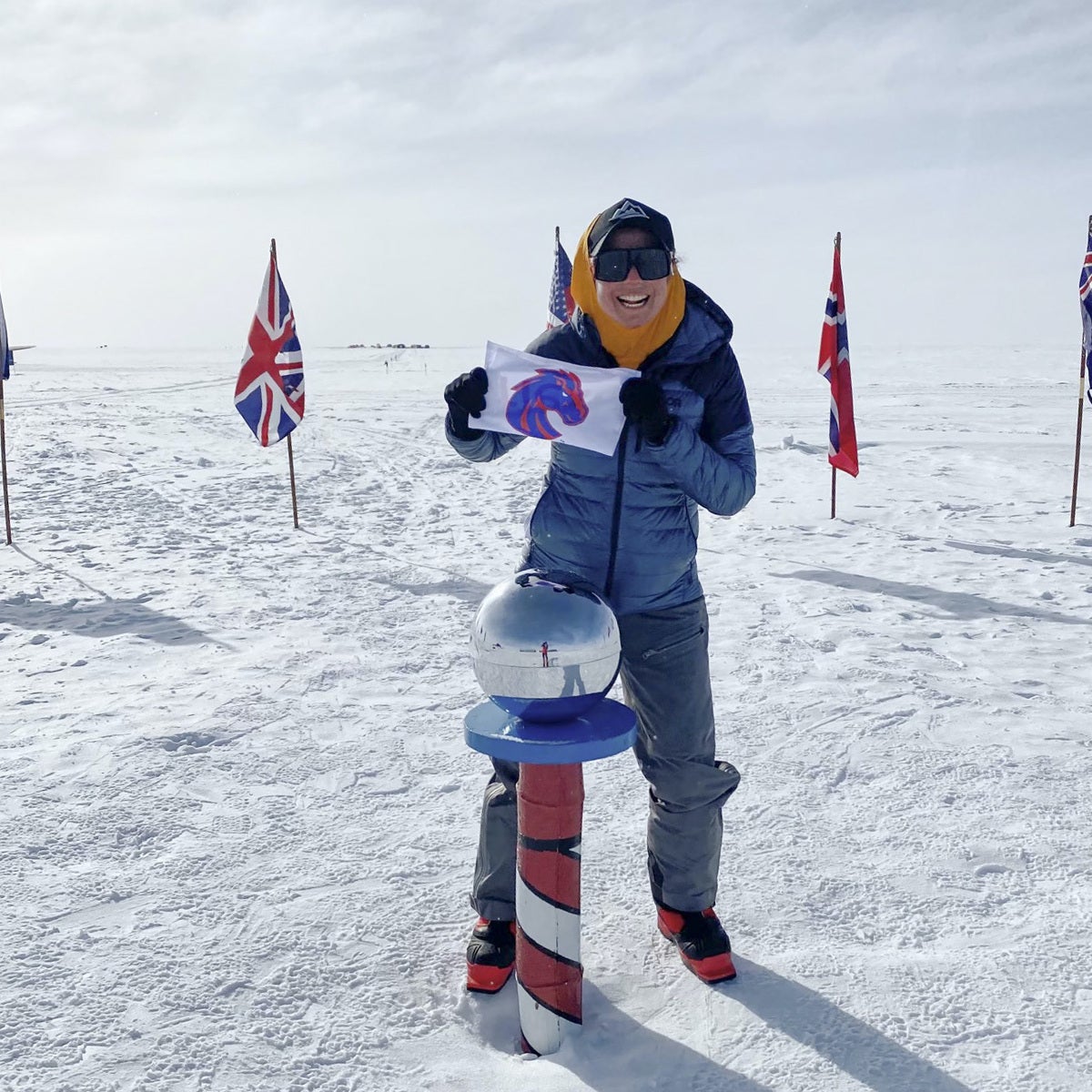 Dorantes holding Boise State Bronco flag while standing over the south pole