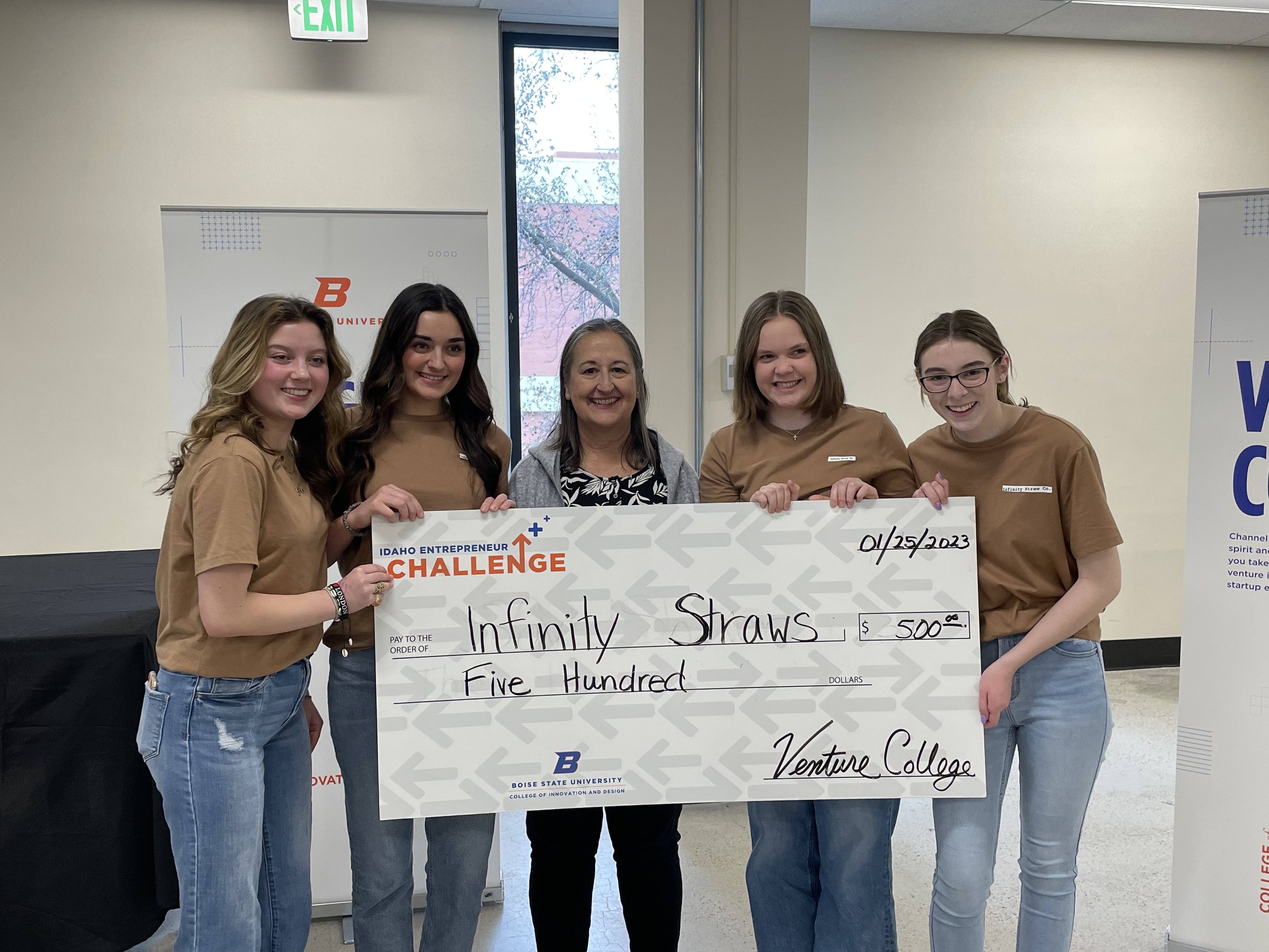 Infinity Straws group holds check for $500