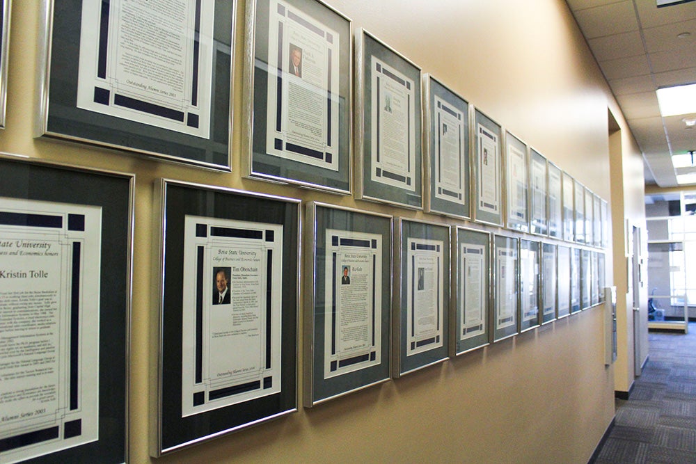Two rows of framed awards hang on the length of a wall.