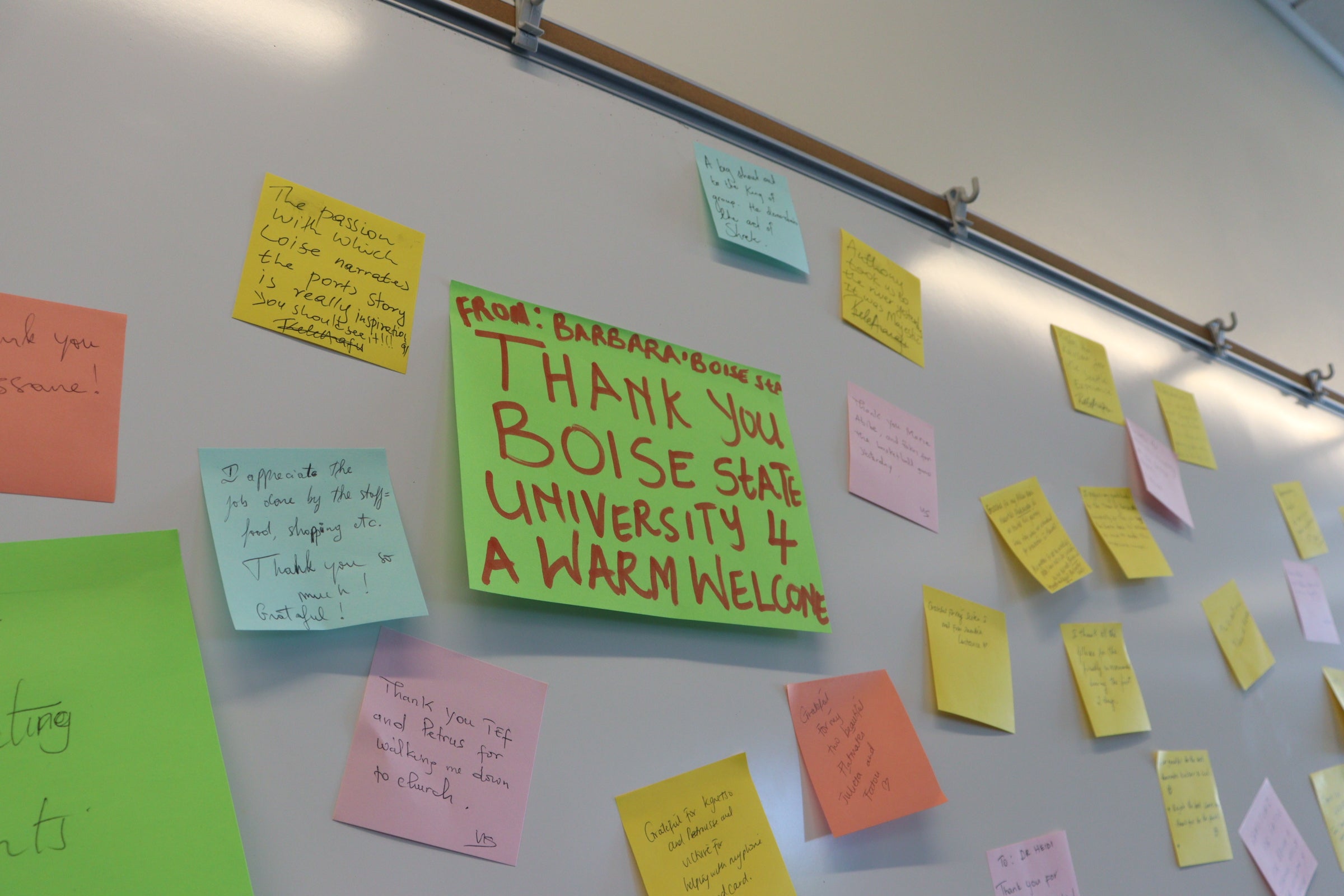 Image of sticky notes with welcoming messages on a whiteboard
