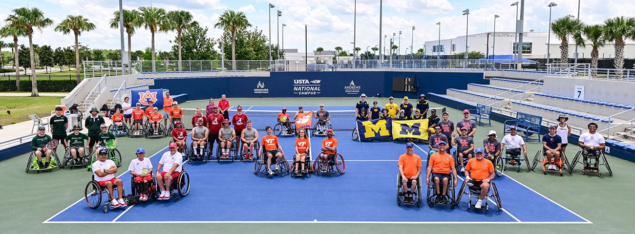 Groups of wheelchair tennis teams from different universities pose on a tennis court