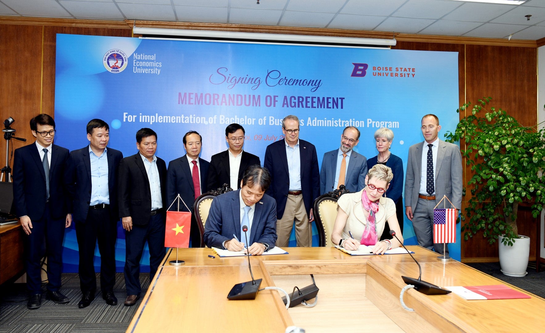 Members of Boise State and National Economics University in Vietnam gather in a conference room to sign new agreement