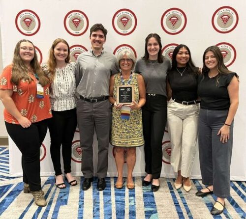 Members of Boise State Beta Alpha Psi chapter stand in front of a backdrop holding the Platinum Challenge Award