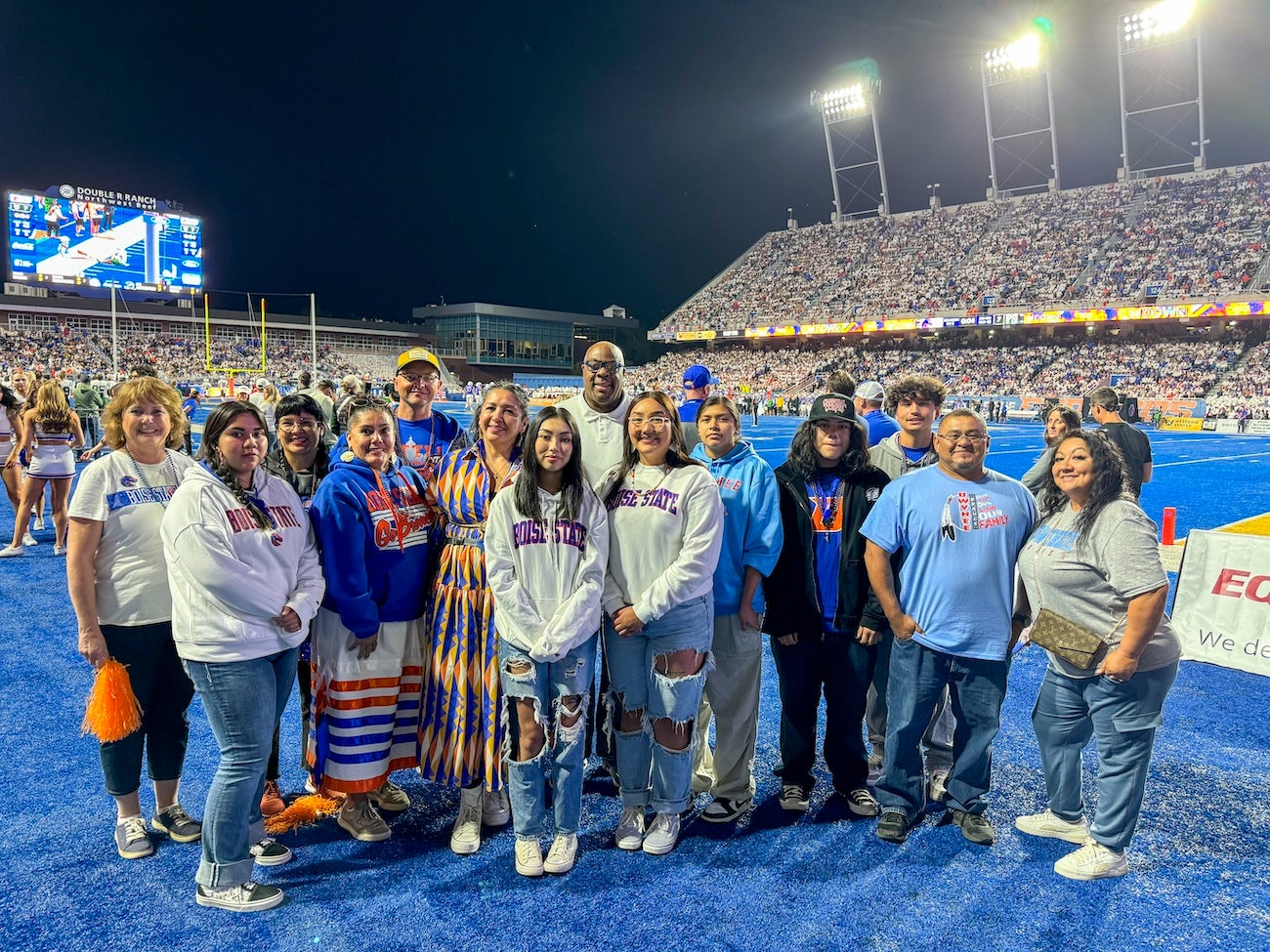 Persons pose on the football field