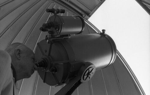 Black and white photo of Boise State Interim President Richard Bullington looking through Science Building telescope.