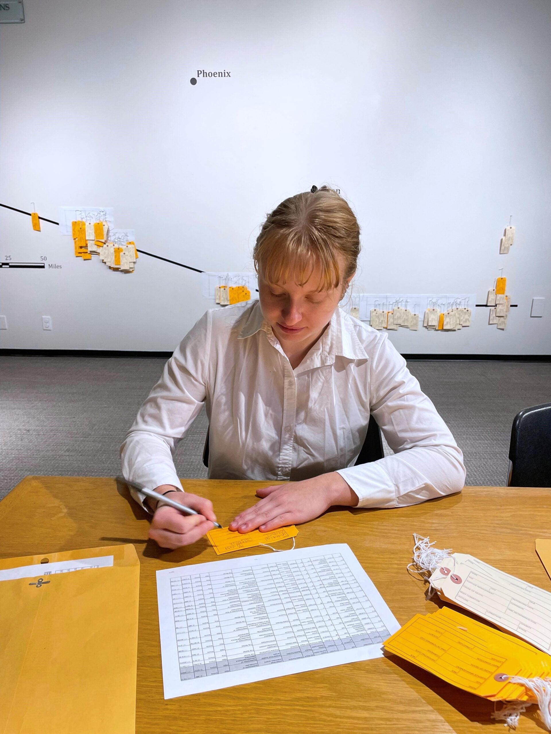 A student writes at a desk