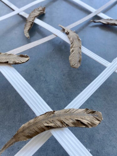 A sculpture designed by Eryn Pierce, featuring a wood lattice and feathers. 