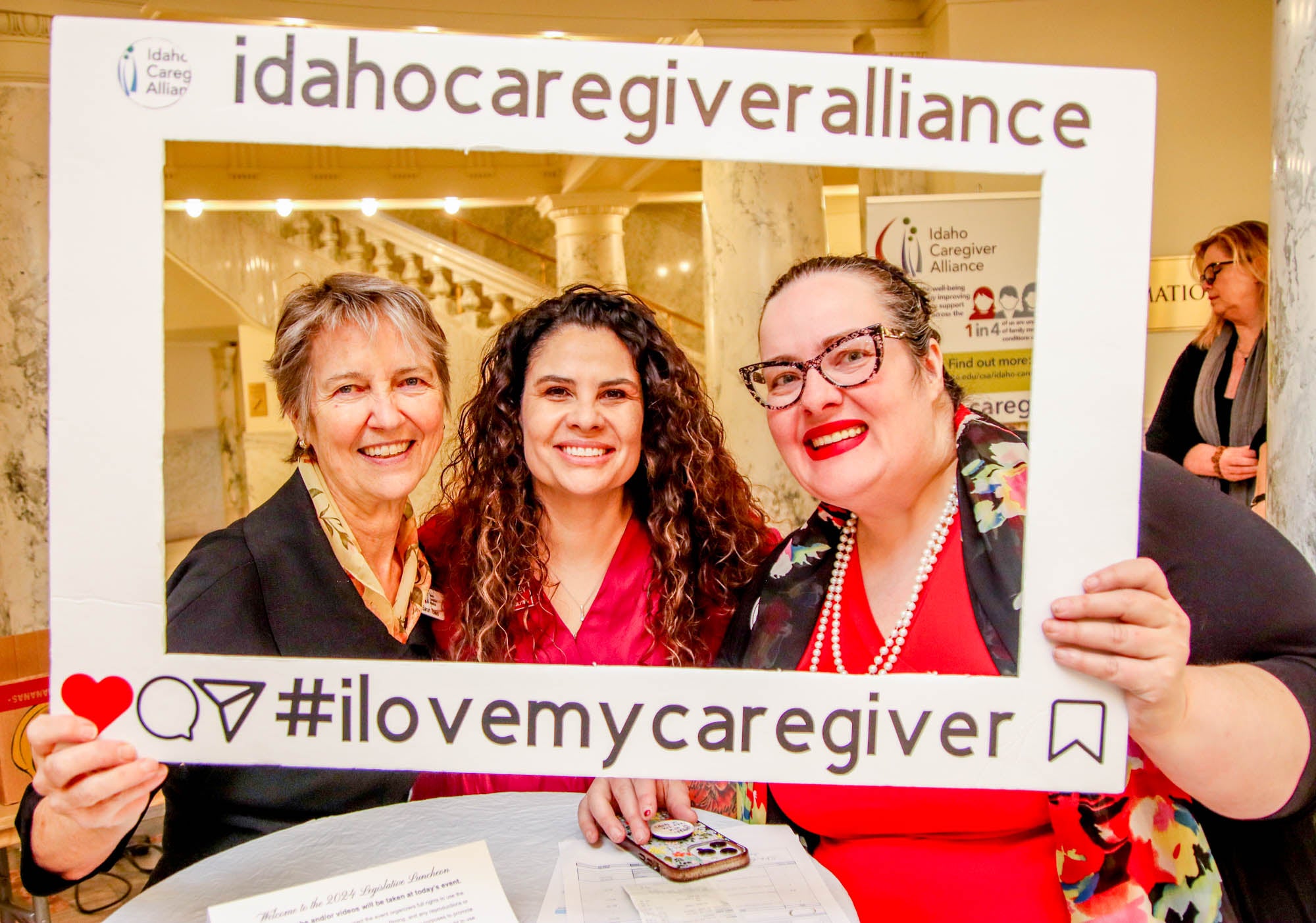 Persons pose with a frame that says "Idaho Caregiver Alliance, #ilovemycaregiver"