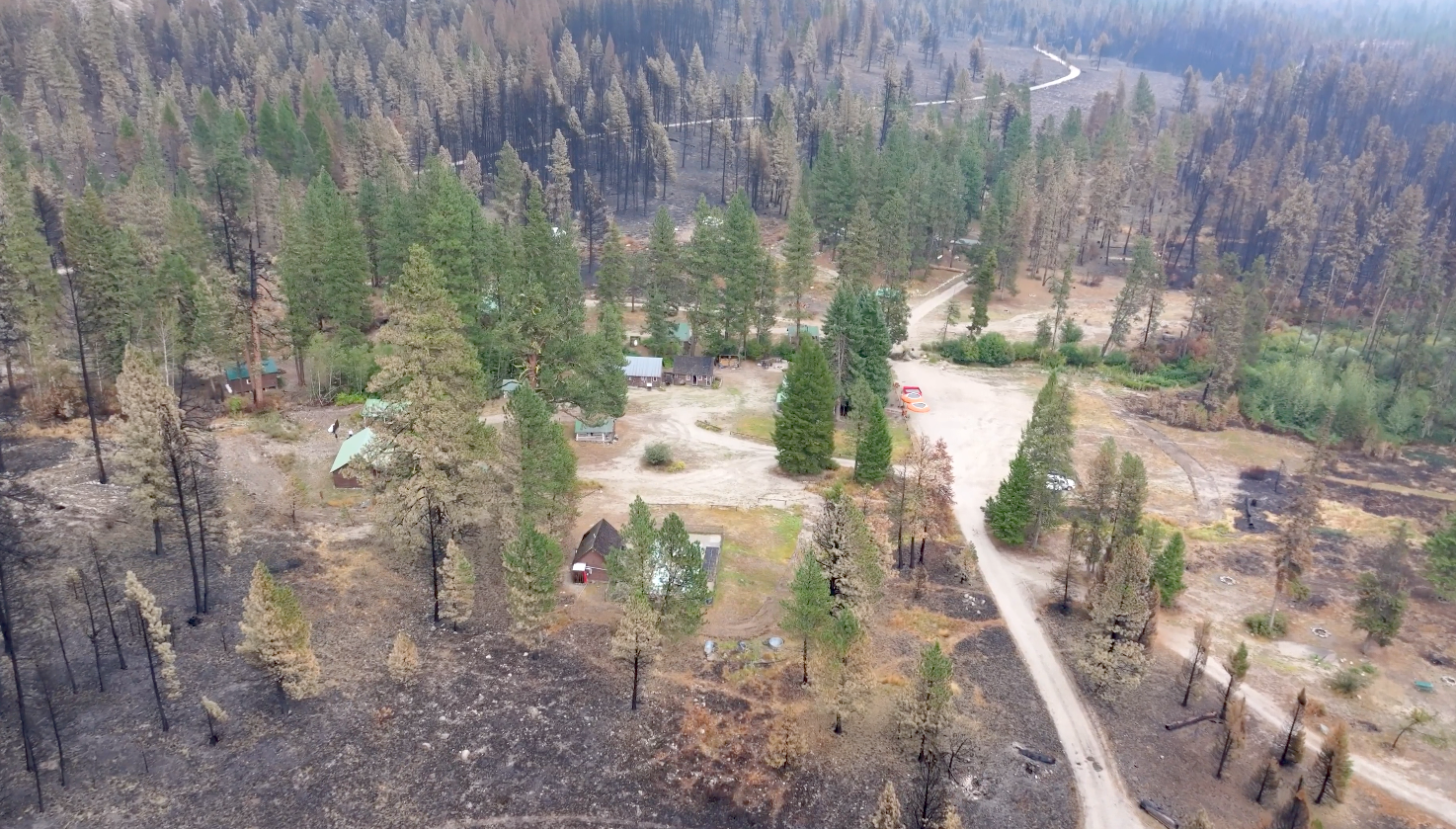 an aeriel, drone shot of a campsite shows where fire burned on the edges in a circle around the campground