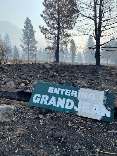 a fallen and burned sign says "Entering Grandjean"