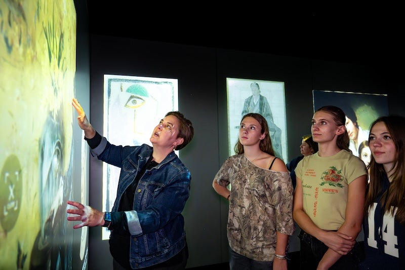 An instructor and students look at digital projections 