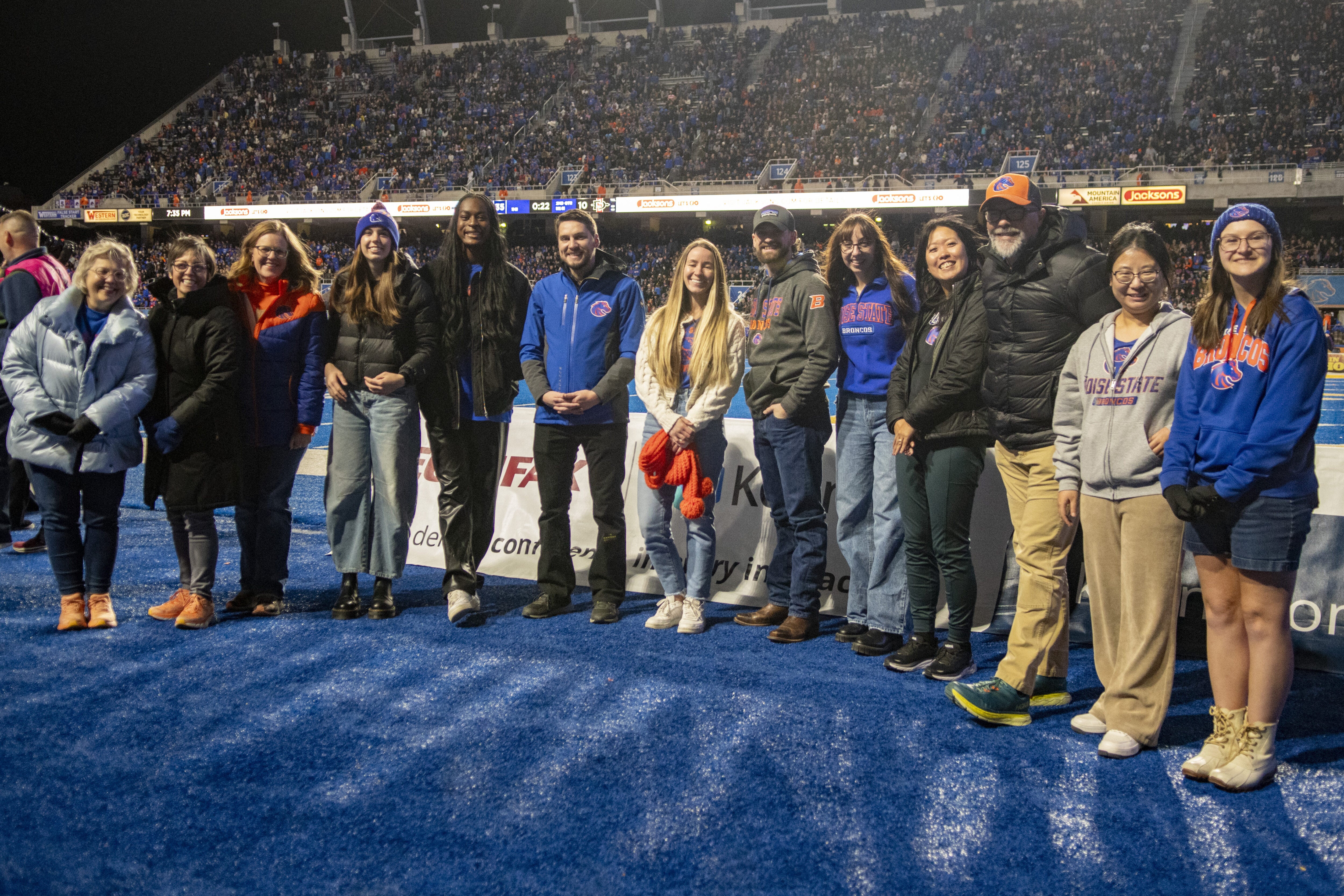 Persons pose on a football field