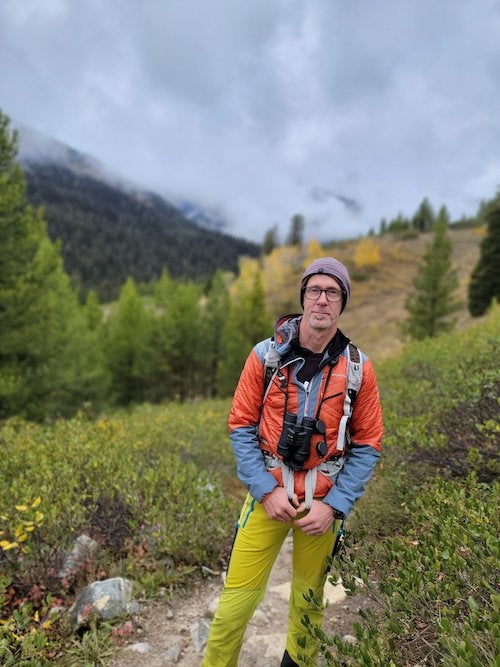 man standing in hiking gear in mountainous terrain