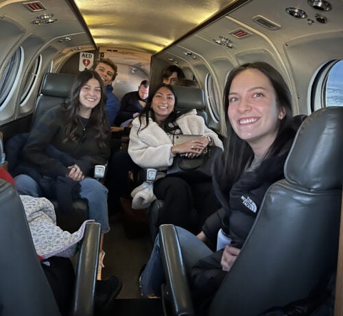 Young people smile from the seats of a small private plane