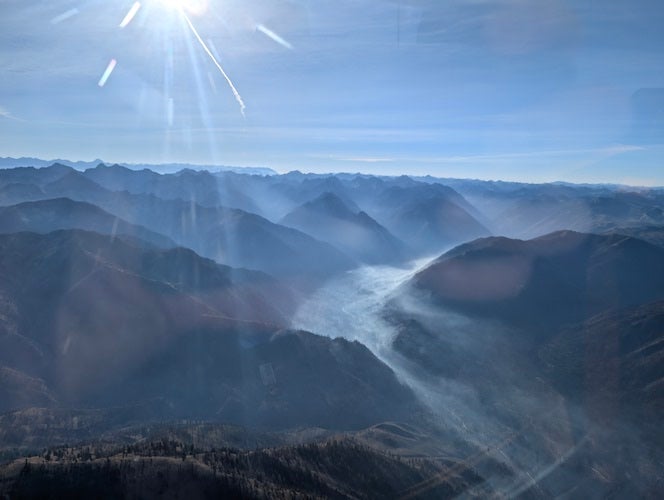 A mountain range with patches of smoke