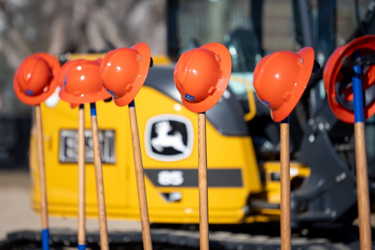 Hard hats lined up on shovels