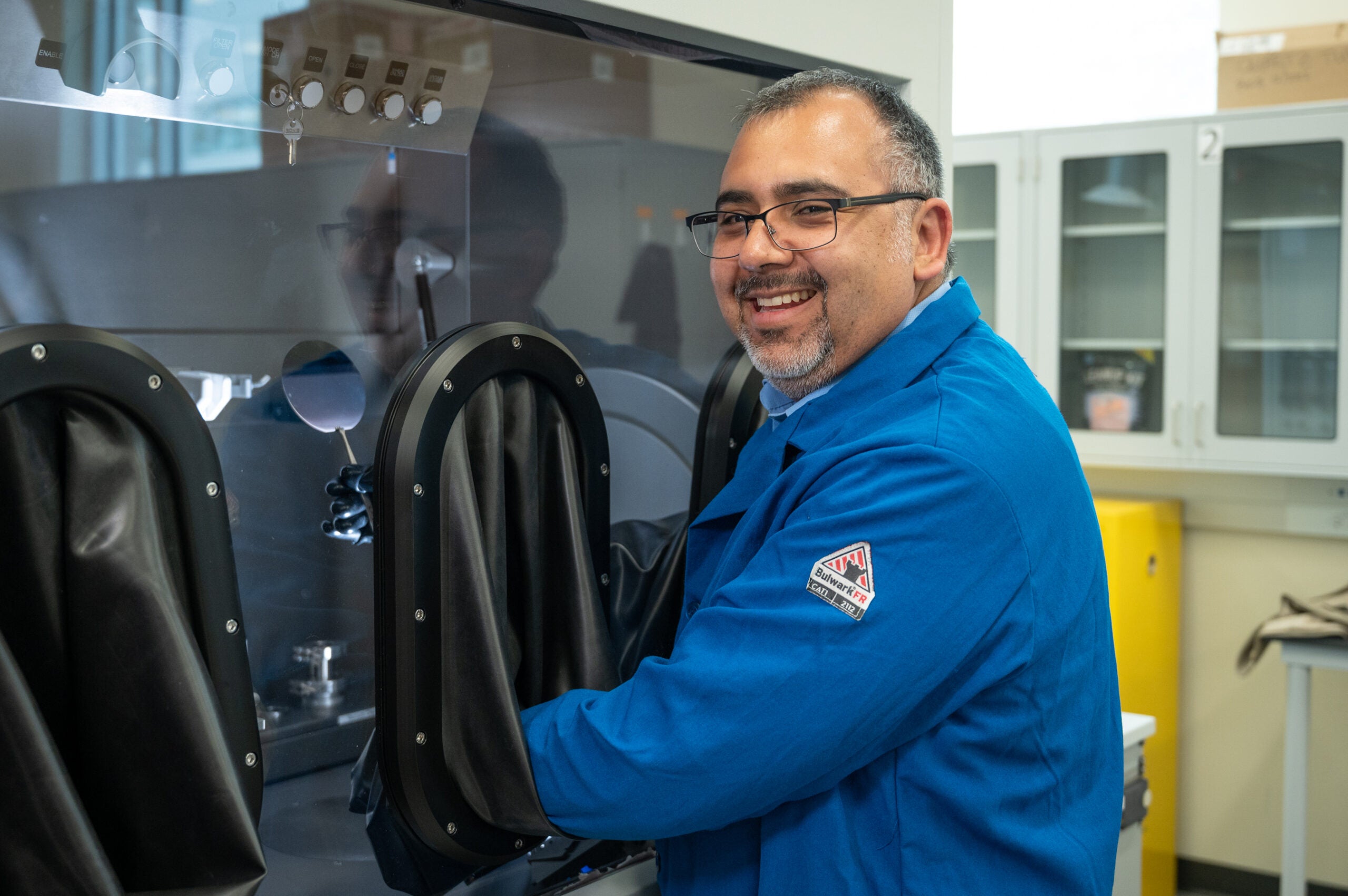 A man smiles as he works in a lab