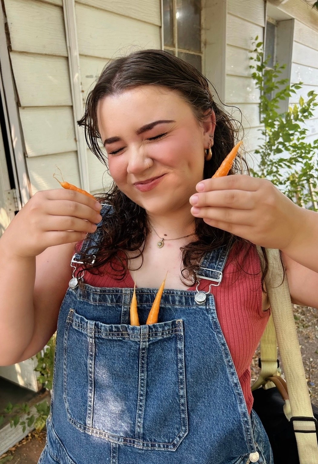 Maci Mattravers smiles with fresh carrots. 