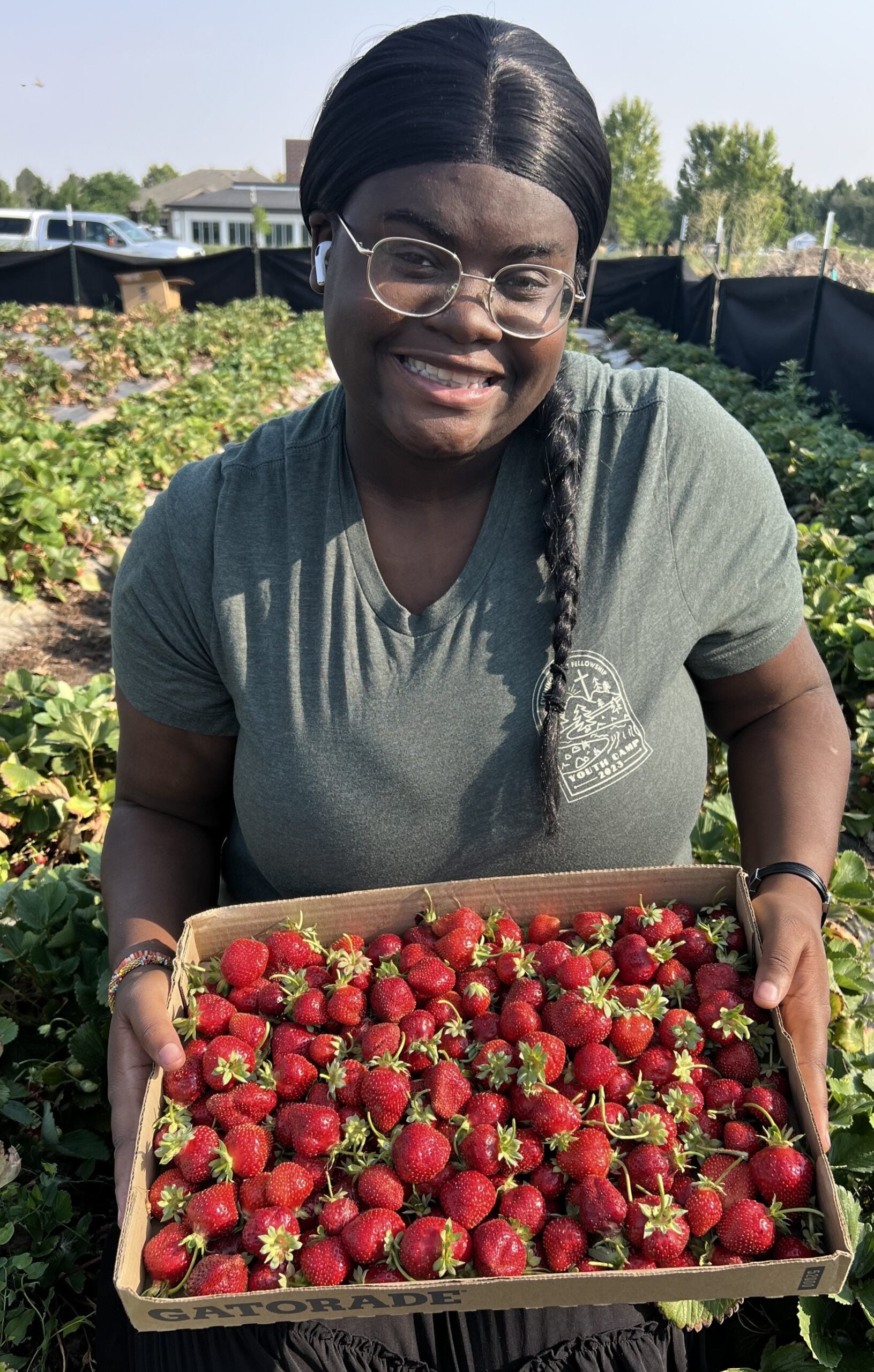 Alice Mwamba smiles with a box of fresh strawberries. 