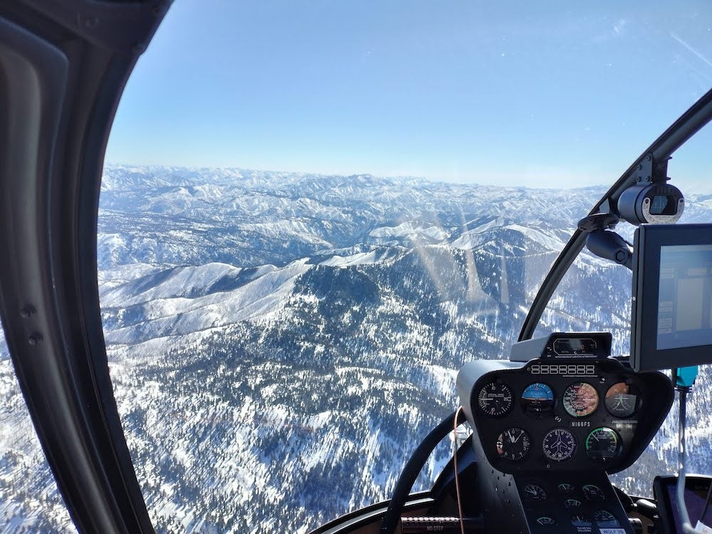 View over snowy, alpine region from the cockpit of a helicopter