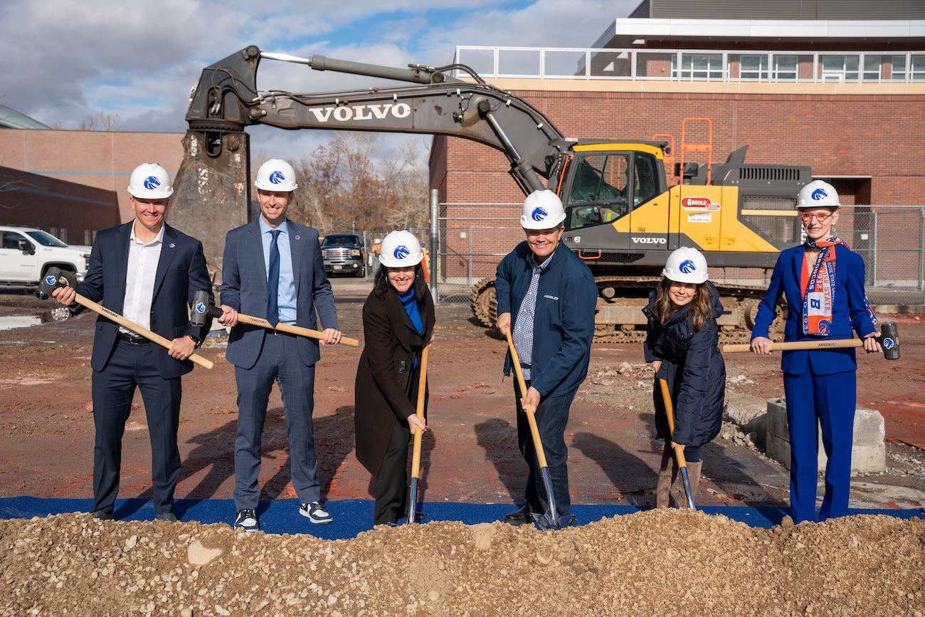 Persons in hard hats pose at groundbreaking ceremony