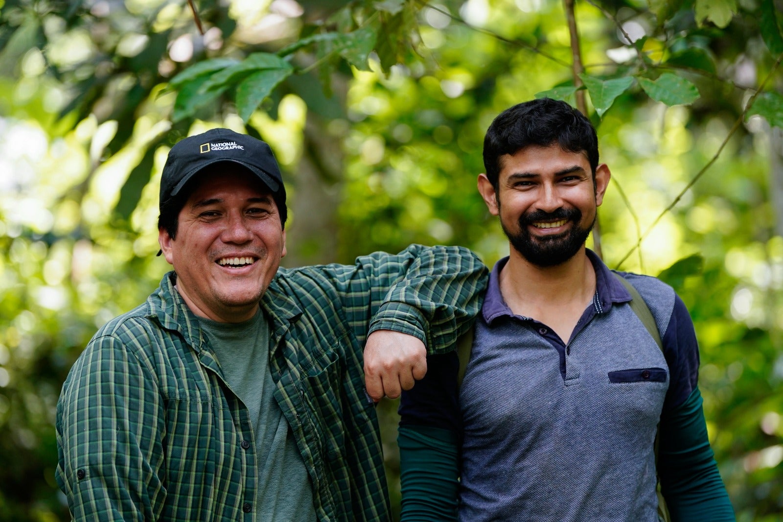 Two persons pose in a jungle setting 