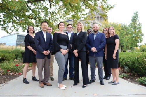 A group of persons poses at the Idaho Capitol