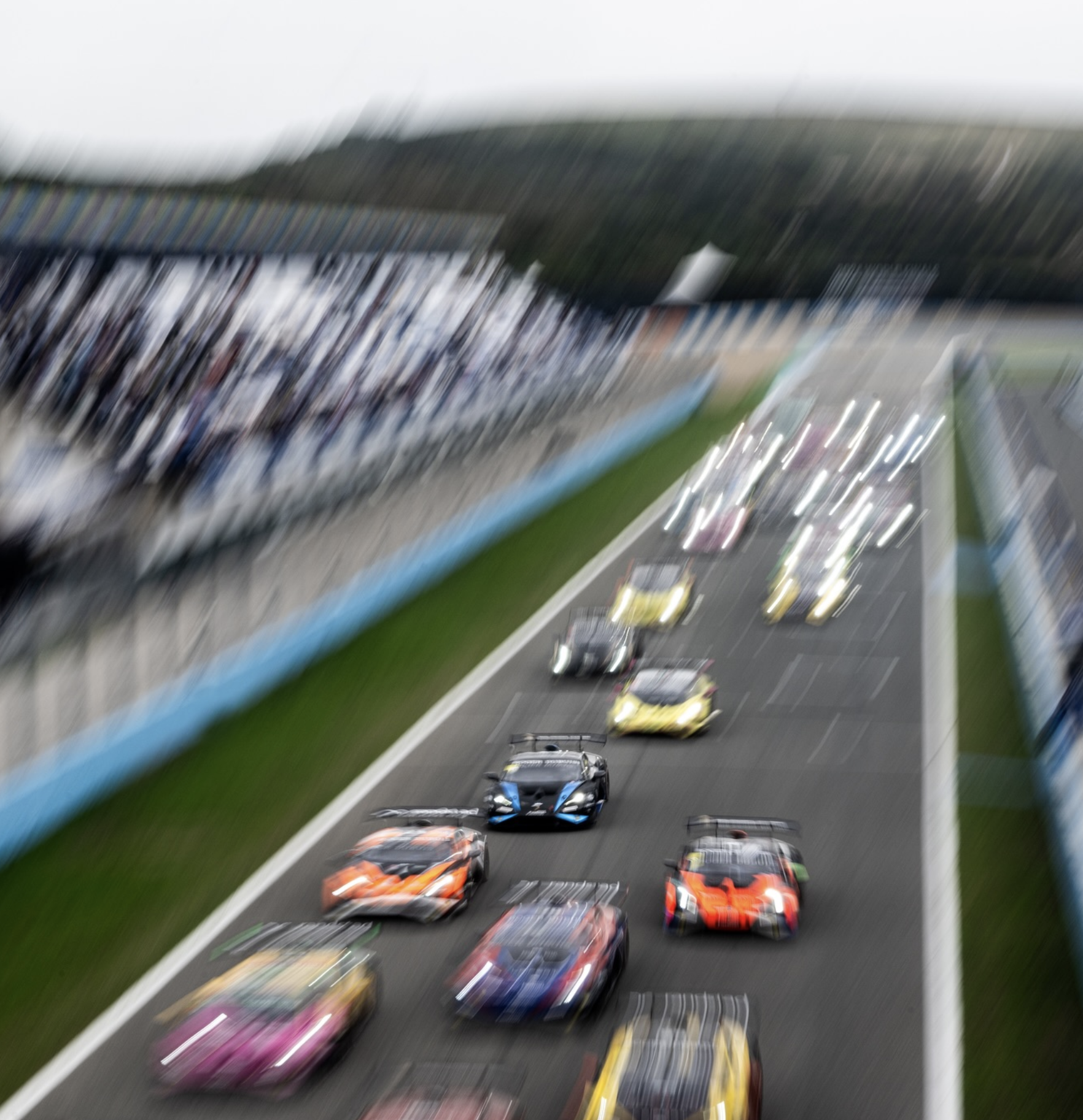 Cars blurred as they speed along a a race track